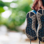 Kožená turistická obuv počas čistenia kefou a prípravkom.