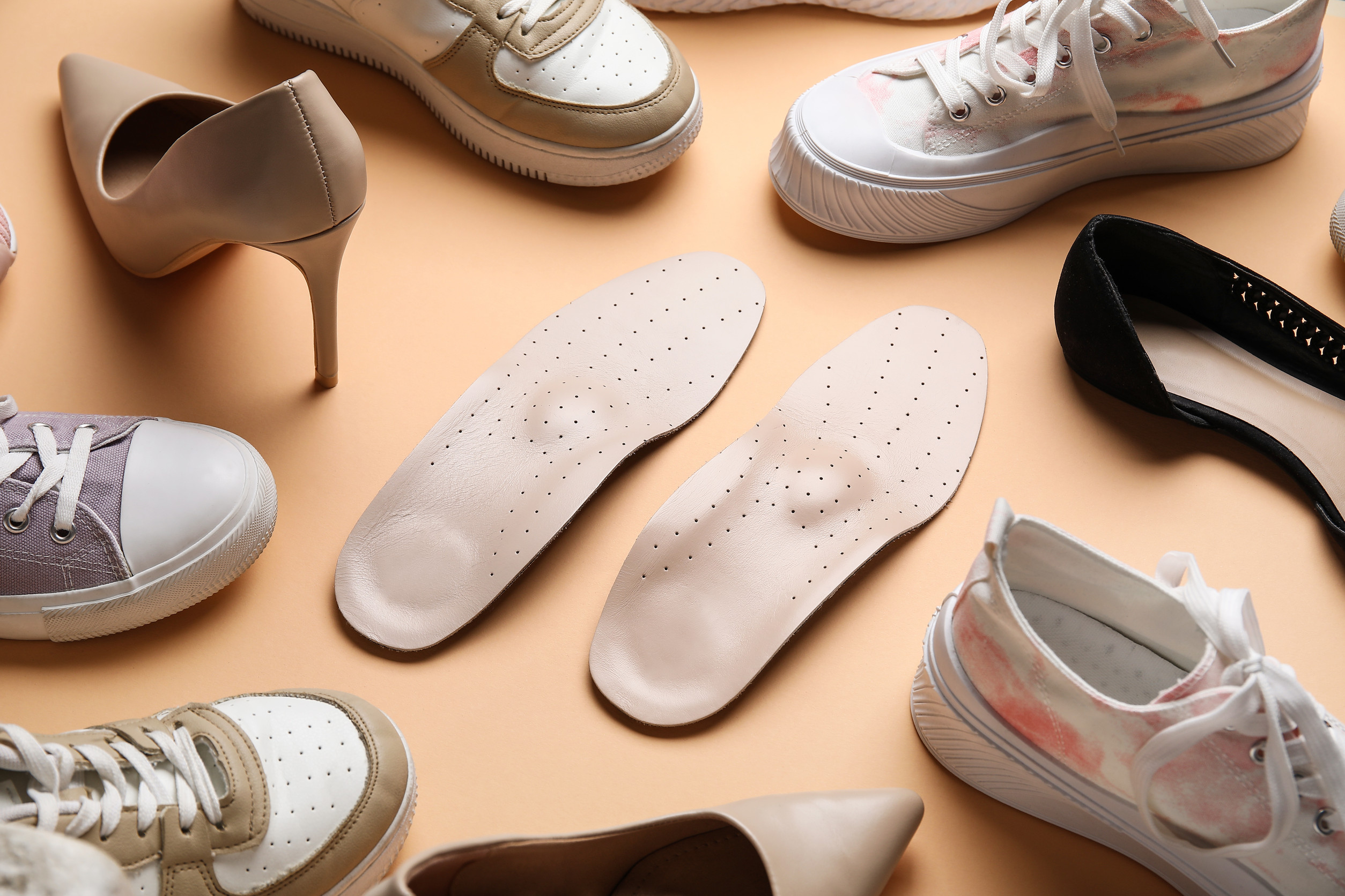 Turistické topánky s vybratou vložkou položené na kamennom podklade.