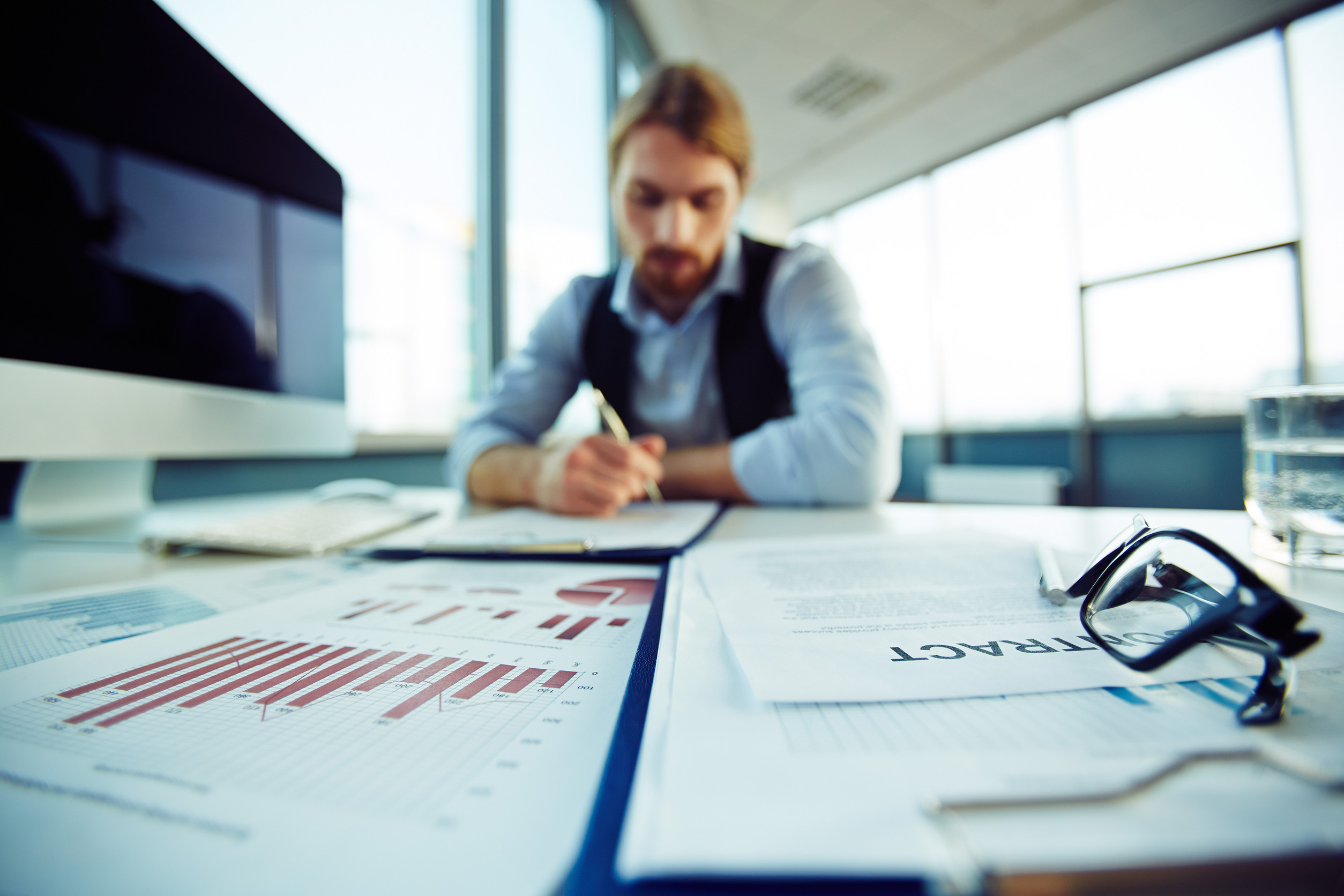 Podnikateľ vypĺňa dokumenty na registráciu predmetu podnikania pri stole.