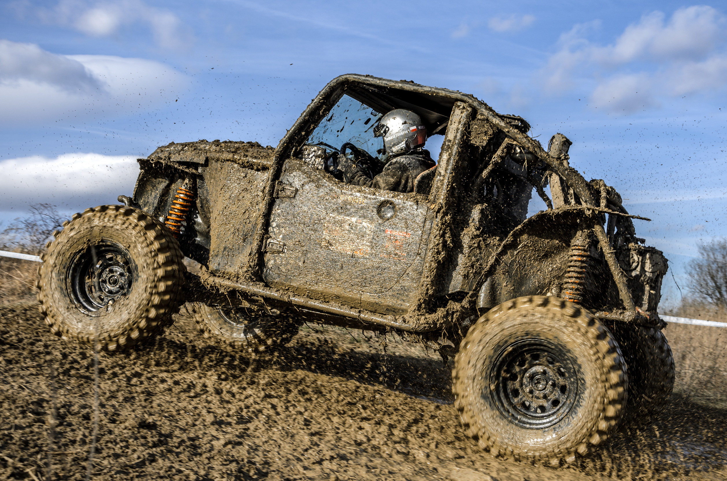 Majiteľ umýva zablatenú štvorkolku tlakovým čističom po jazde v teréne.