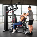 Domáci silový tréning na posilňovacej lavici s činkami a vežou