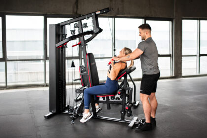 Domáci silový tréning na posilňovacej lavici s činkami a vežou