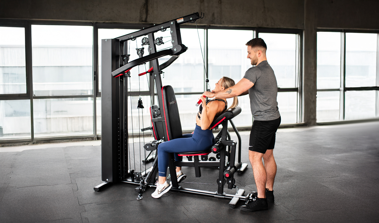 Domáci silový tréning na posilňovacej lavici s činkami a vežou