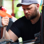 Majiteľ kontroluje a pripravuje štvorkolku na sezónu v garáži, vykonáva základnú údržbu a servis.