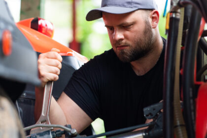 Majiteľ kontroluje a pripravuje štvorkolku na sezónu v garáži, vykonáva základnú údržbu a servis.