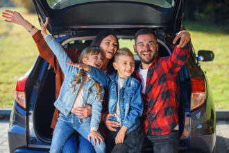 Rodinné auto pripravené na dovolenku so strešným boxom a naloženou batožinou.