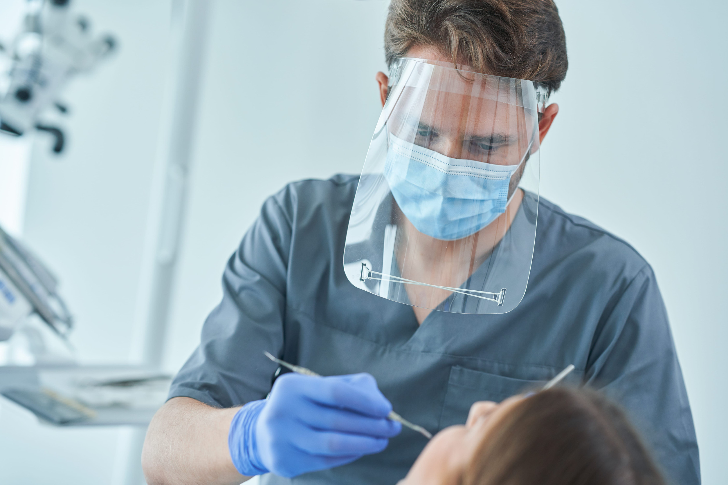 Dentálna hygienička vykonávajúca profesionálne čistenie zubov pacientovi v ambulancii.